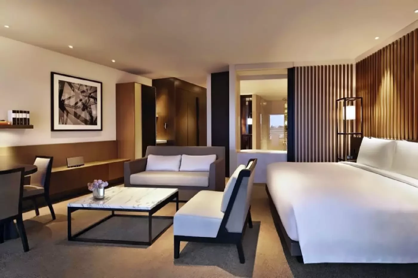 Bedroom and seating area at Capella Sydney with a sofa beside the bed
