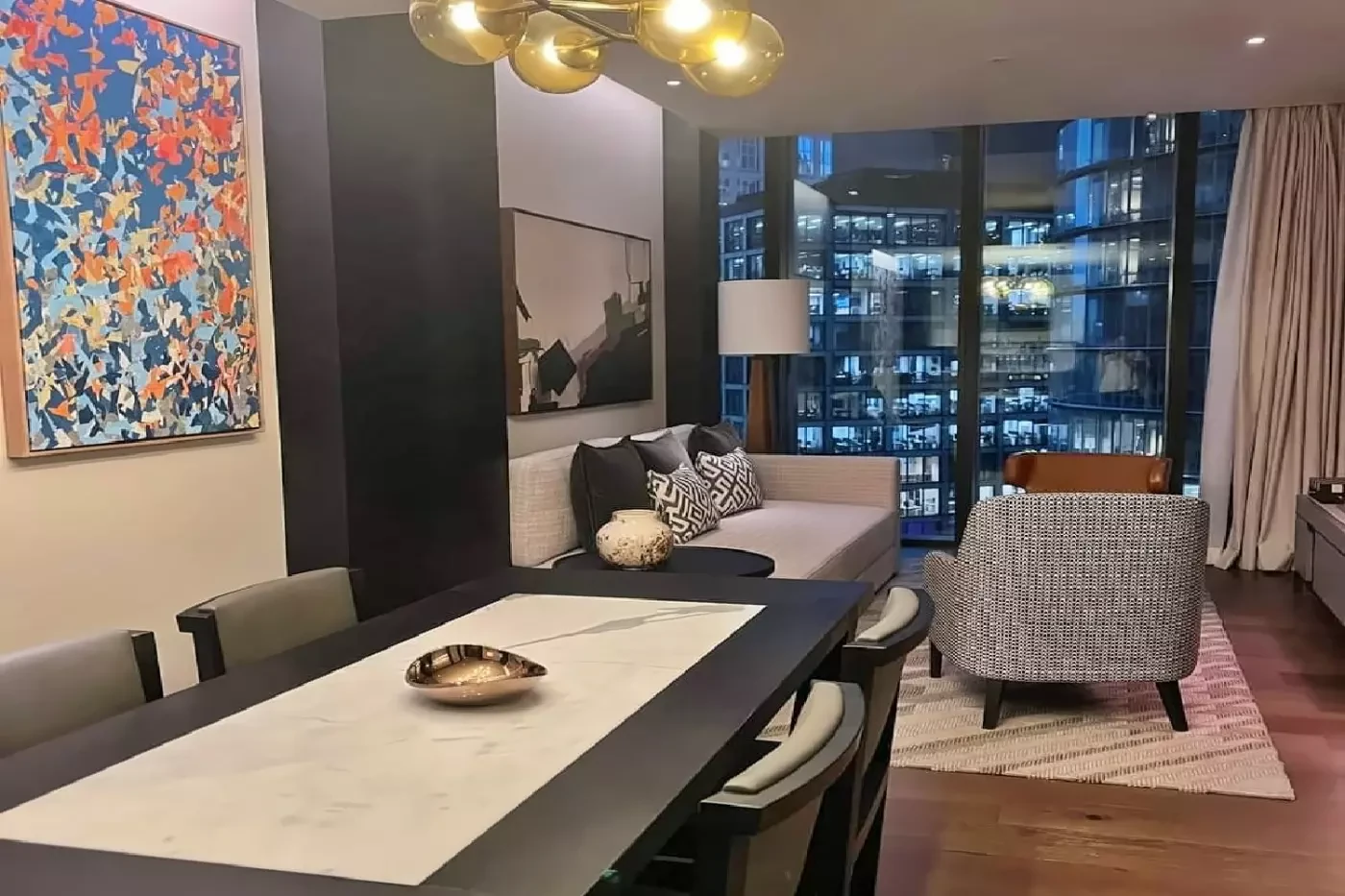 Living and dining space in a Capella Sydney suite with a sofa beside the window