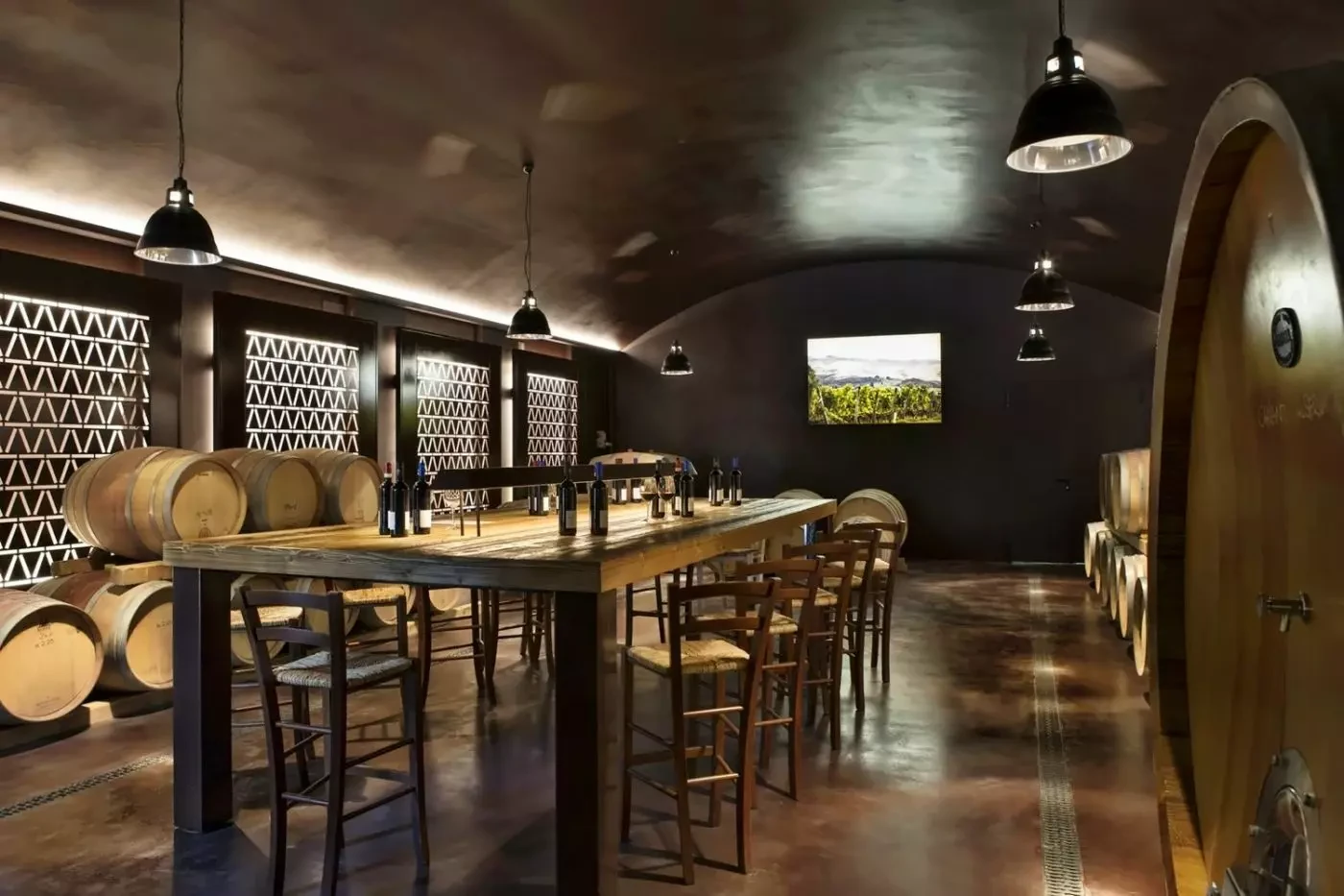 Long tasting table and wine barrels in a cellar at Castelfalfi