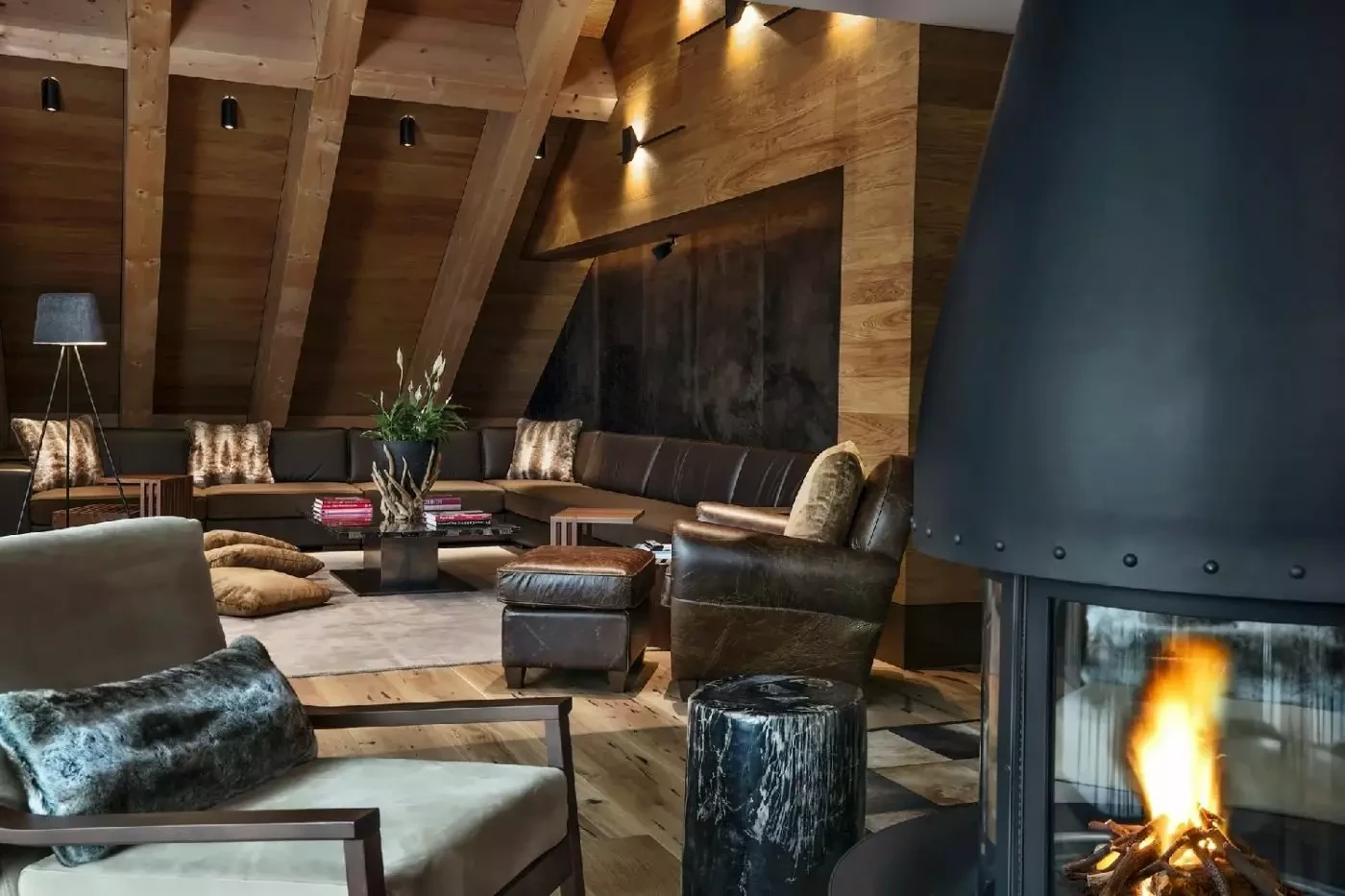 Deep upholstered seating beside a fireplace at The Chedi Andermatt