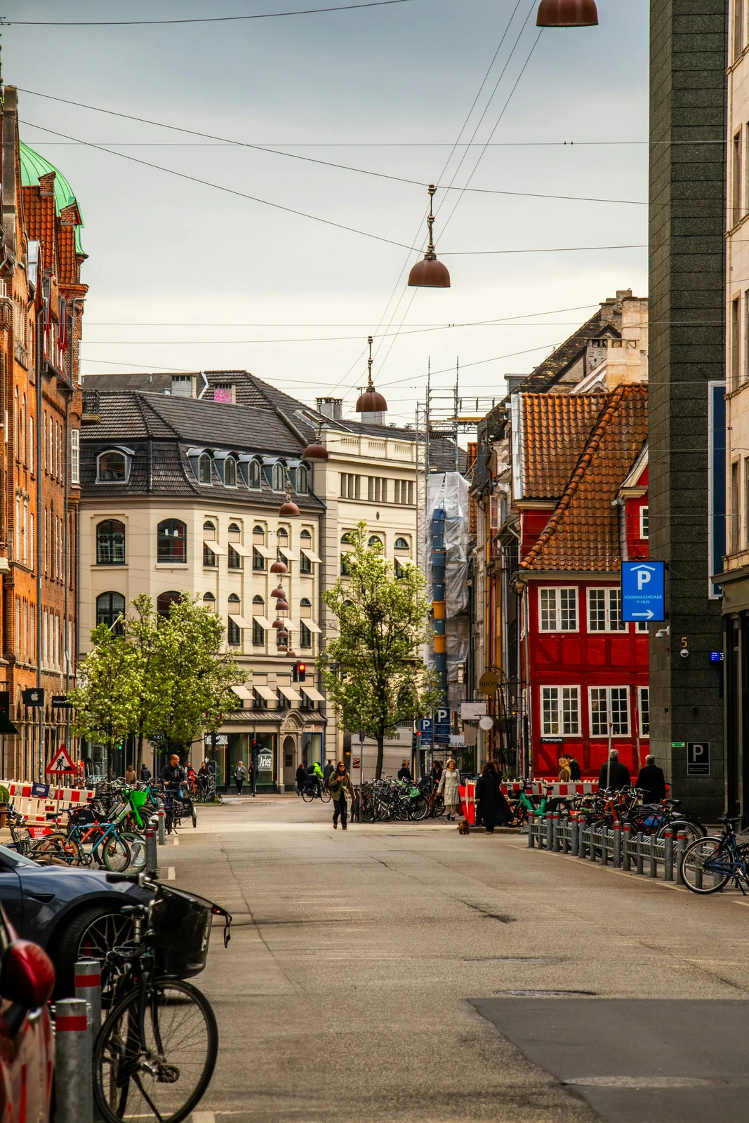 Bicycles and pedestrians on a Copenhagen street lined with historic buildings