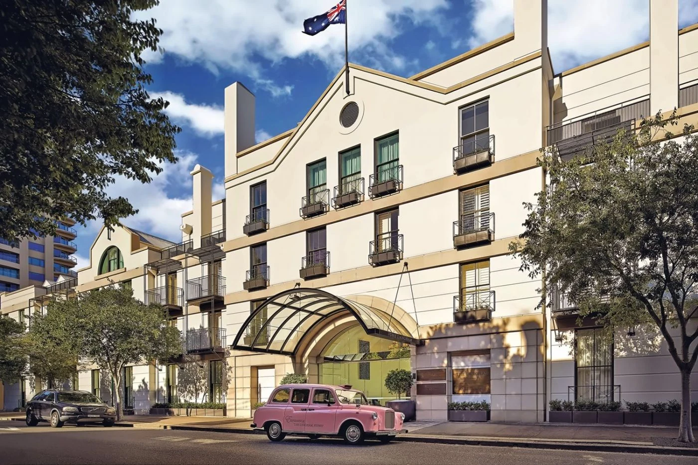 The Langham Sydney entrance on Kent Street, with the hotel's pink car outside