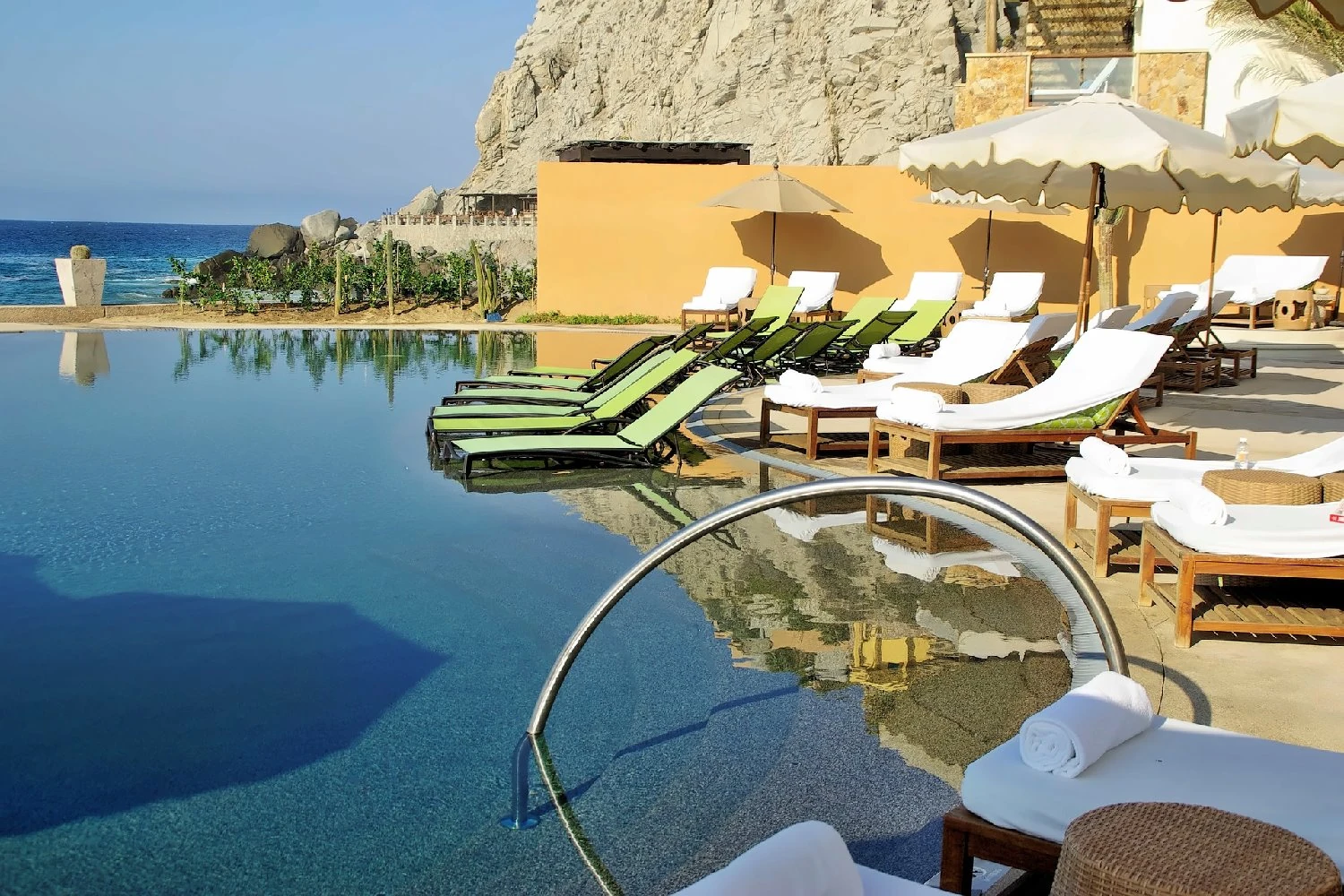 Resort pool with loungers and a view across the sea