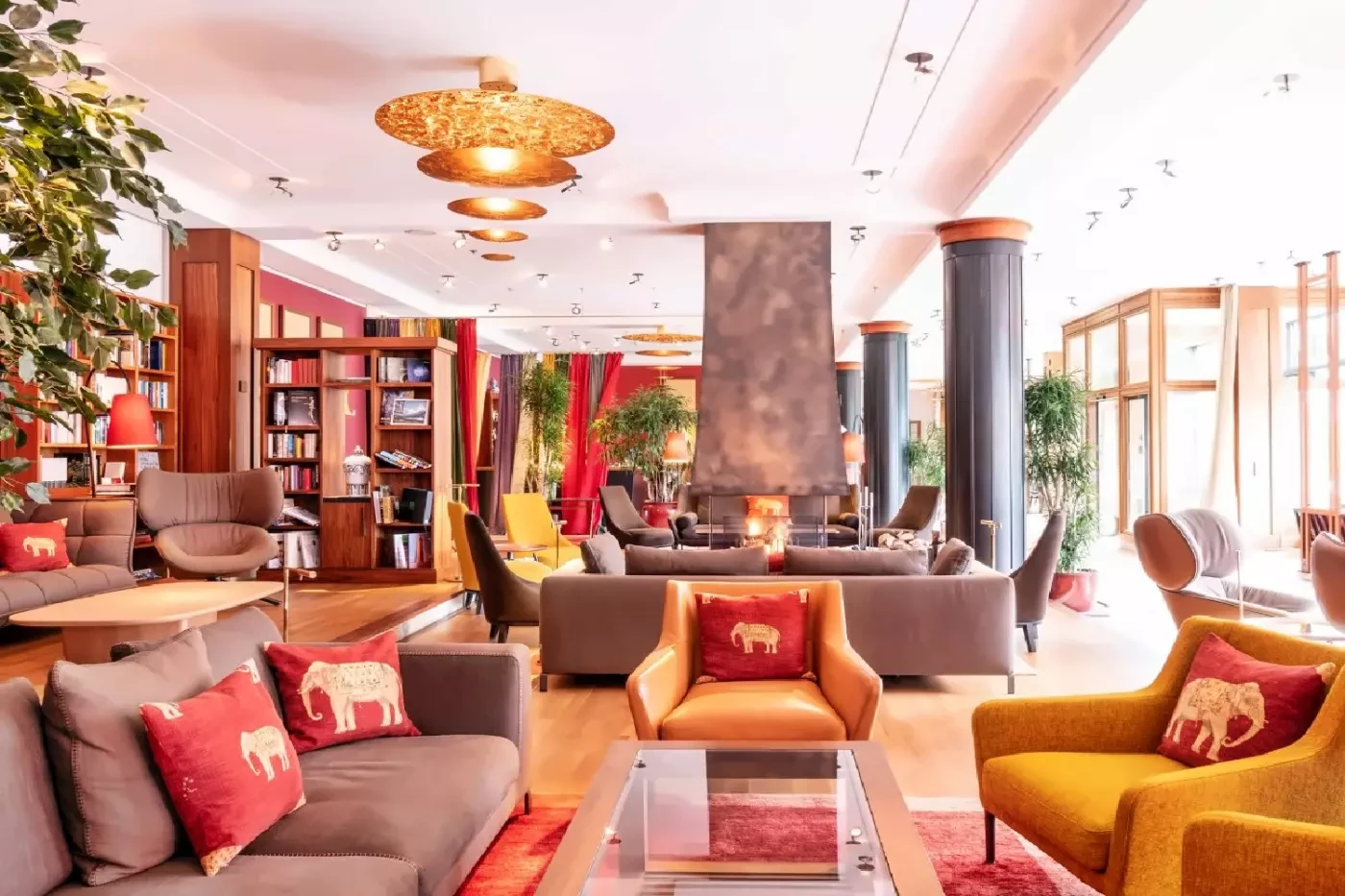 Colorful seating and bookshelves in a light-filled lounge at Schloss Elmau