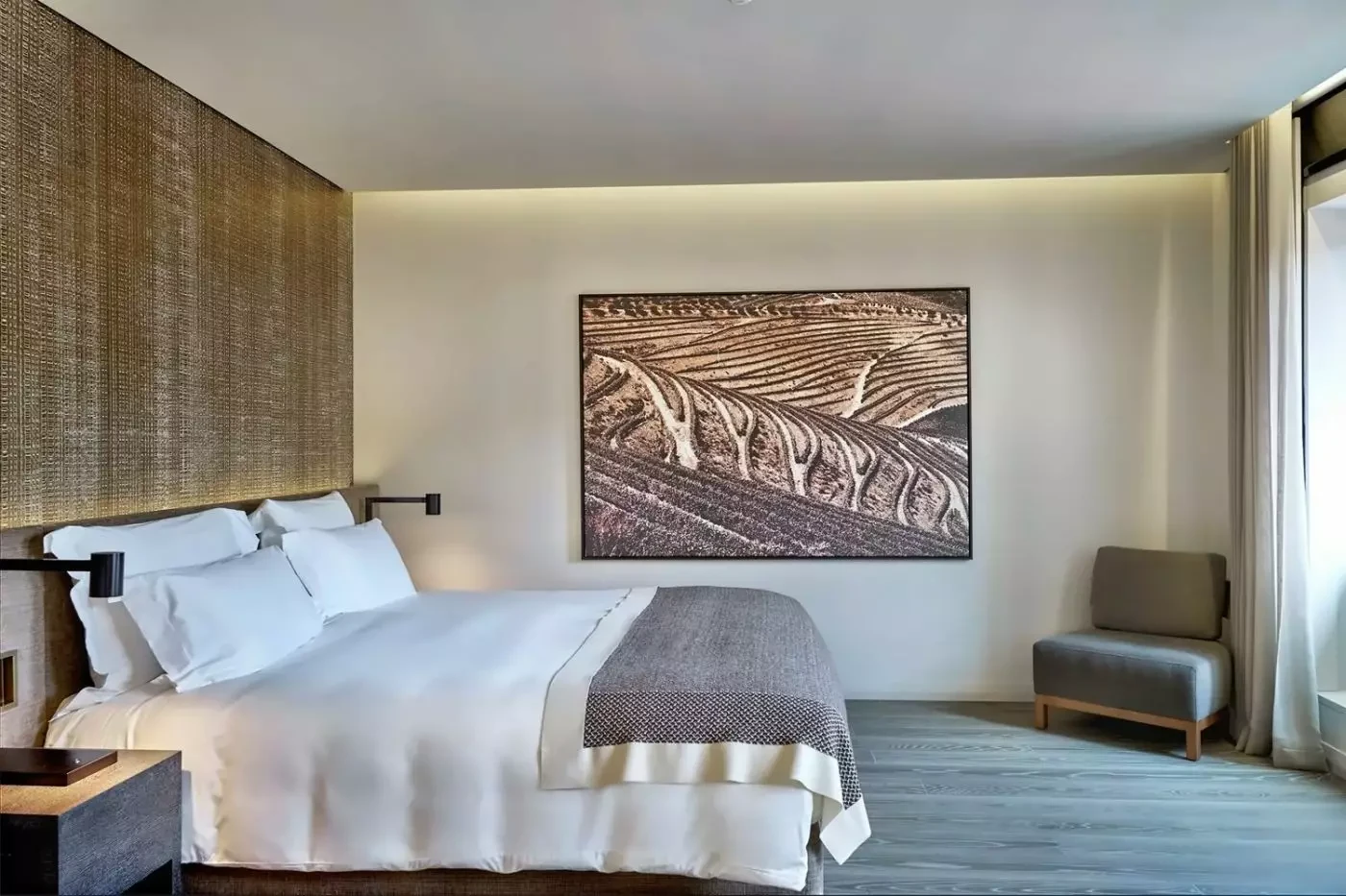 Bedroom at Six Senses Douro Valley with timber headboard and vineyard artwork