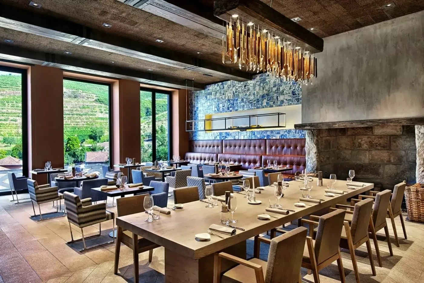 Dining tables beside a stone fireplace at Six Senses Douro Valley
