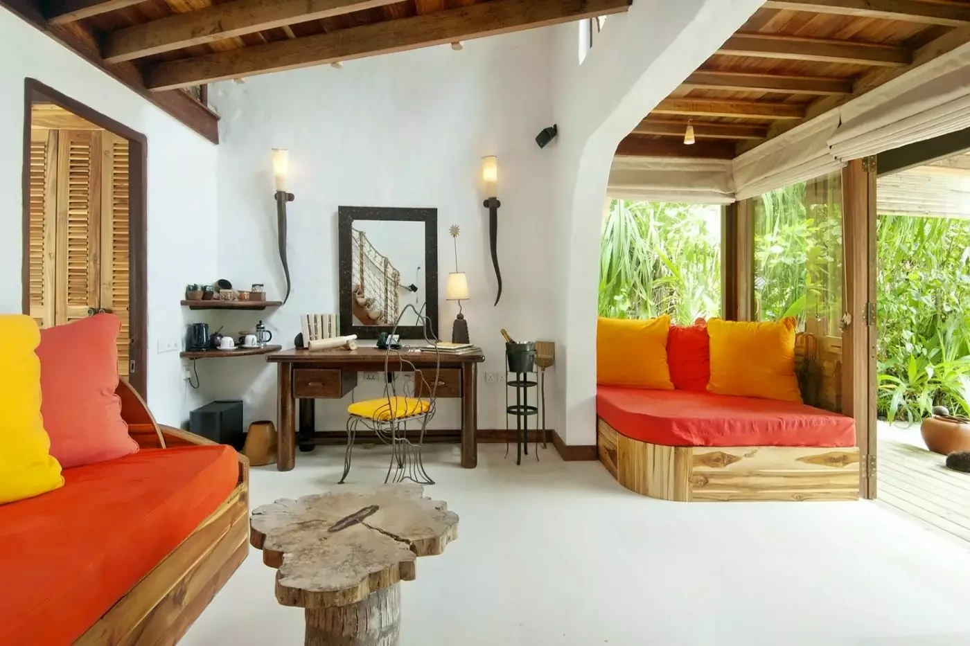 Open villa living space at Soneva Fushi with bright upholstered seating and garden greenery