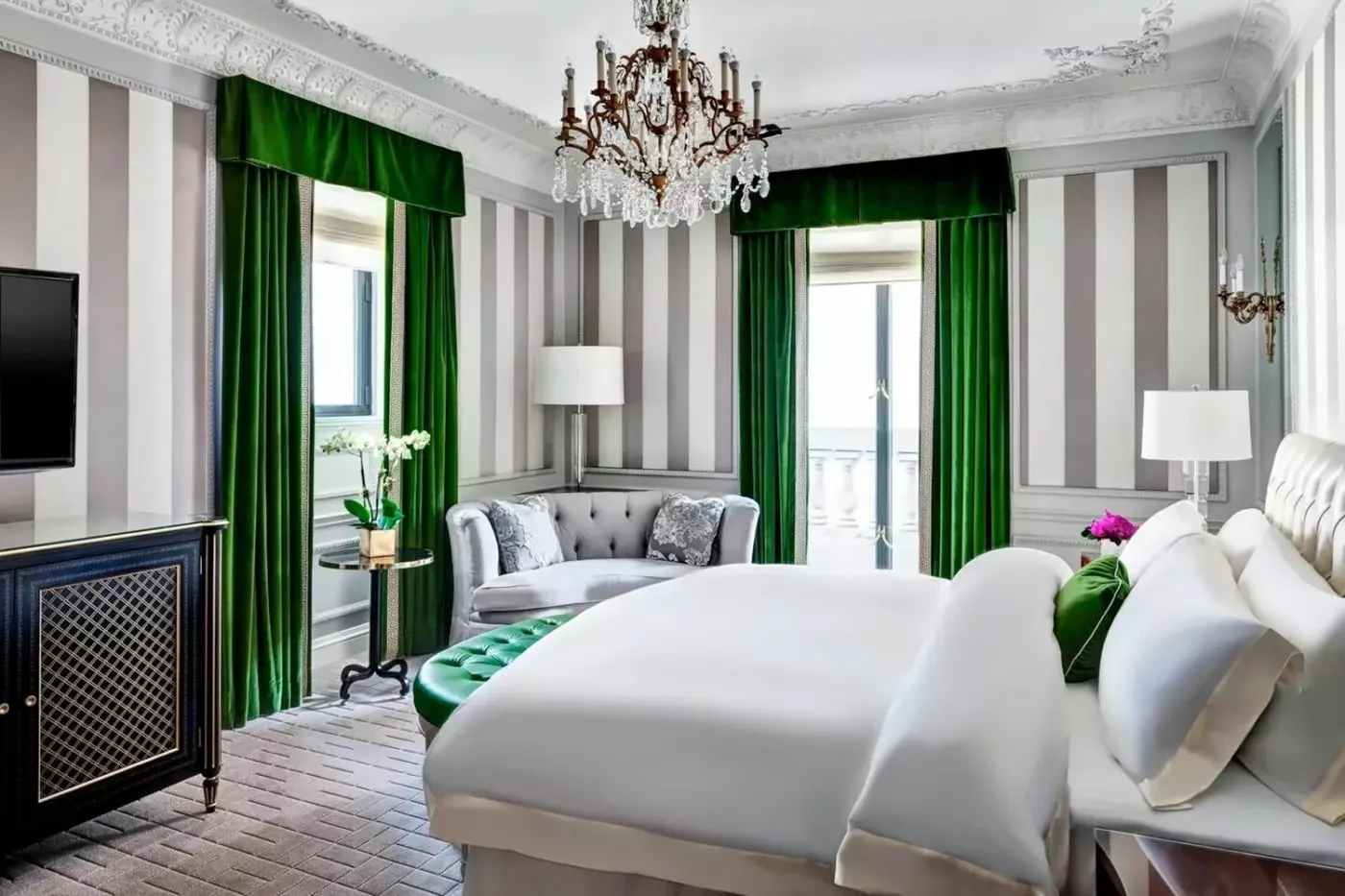 Bedroom at The St. Regis New York with green curtains and a chandelier