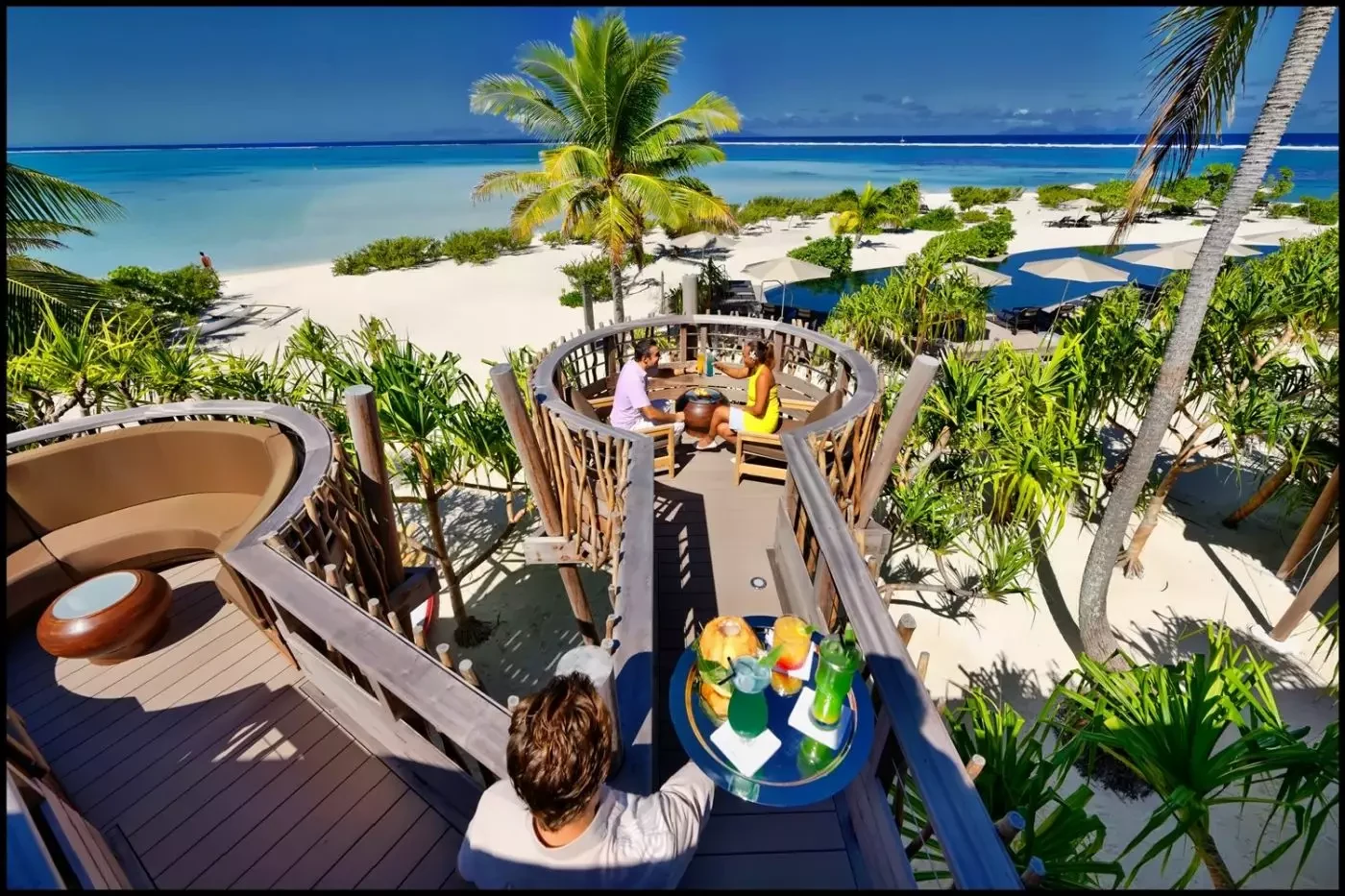 Elevated timber terrace of Te Manu Bar among palms at The Brando